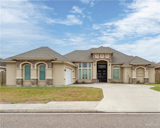 view of front of property with a garage, driveway, a front yard, and stucco siding