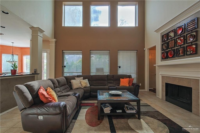 tiled living room with a fireplace, a towering ceiling, and ornate columns