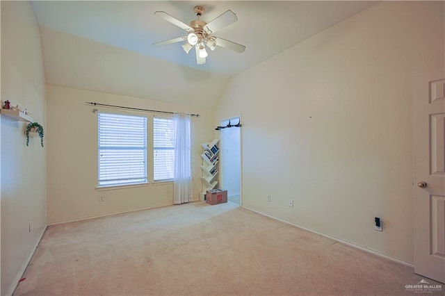 empty room with ceiling fan, lofted ceiling, and light carpet