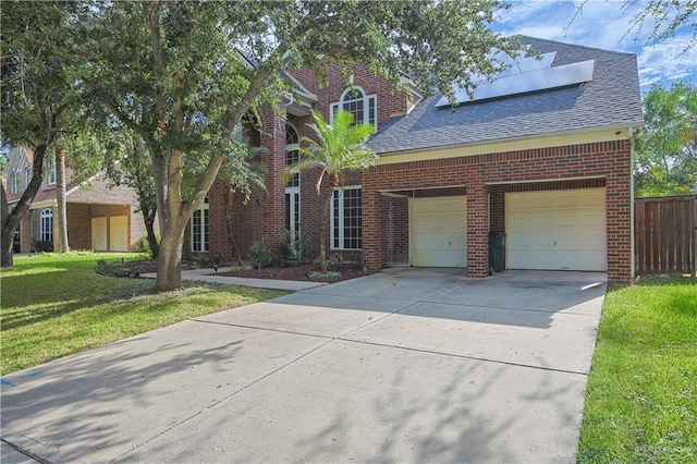 view of front of home with solar panels and a front lawn