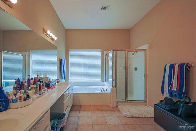 bathroom with tile patterned flooring, vanity, and plus walk in shower