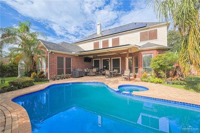 view of swimming pool featuring an in ground hot tub and a patio