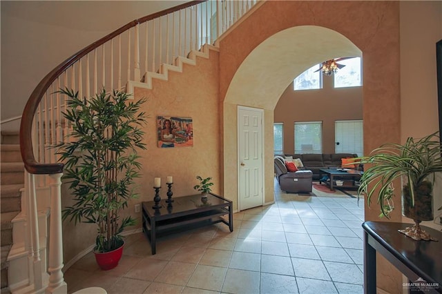 tiled entrance foyer with a towering ceiling