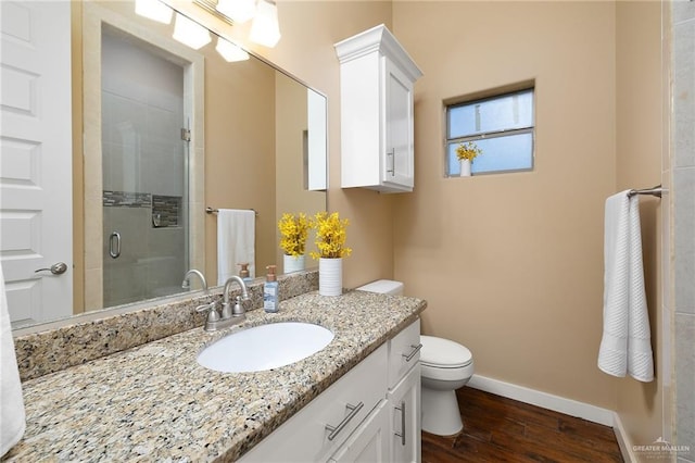 1408 May Dr, Edinburg, TX 78539 - full bath with baseboards, toilet, vanity, wood finished floors, and a stall shower