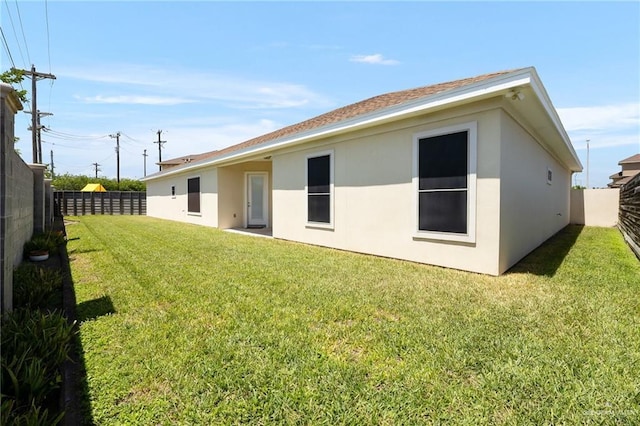 1408 May Dr, Edinburg, TX 78539 - back of house featuring a fenced backyard, stucco siding, and a lawn