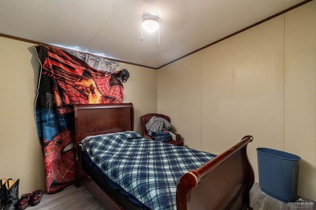 bedroom with hardwood / wood-style floors and crown molding