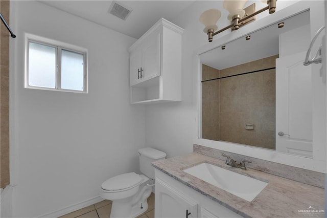 bathroom with toilet, a tile shower, vanity, and tile patterned floors