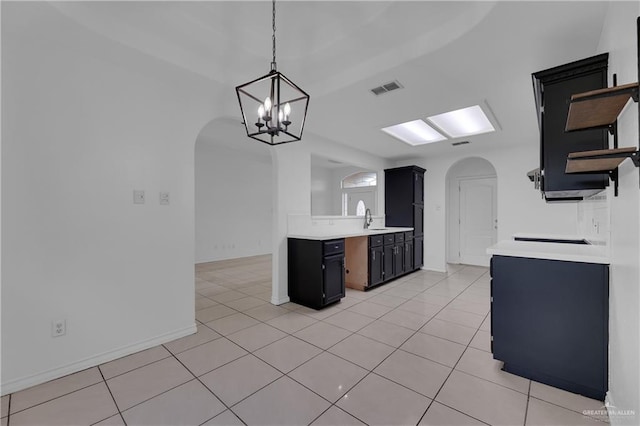 kitchen featuring a chandelier, sink, light tile patterned flooring, and hanging light fixtures