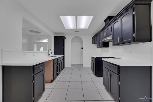 kitchen with decorative backsplash, light tile patterned flooring, and sink