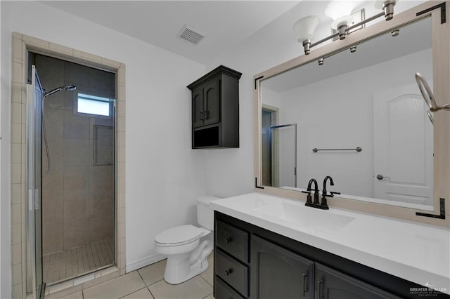 bathroom featuring tile patterned floors, vanity, an enclosed shower, and toilet