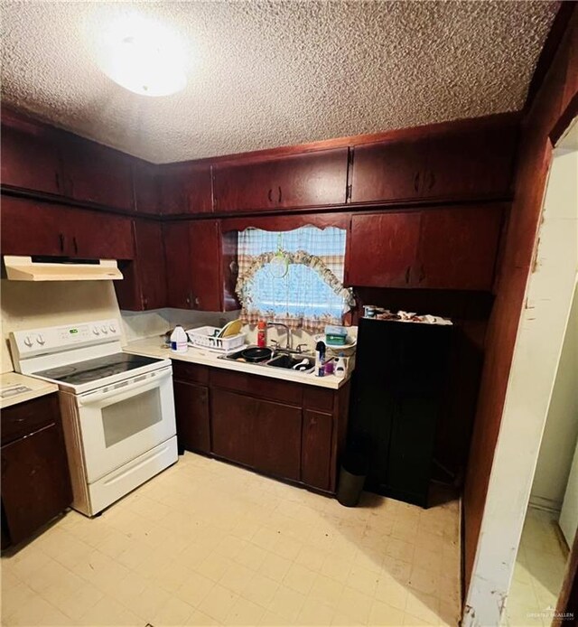593 5th St, Raymondville, TX 78580 - kitchen featuring electric range, under cabinet range hood, a textured ceiling, a sink, and light countertops