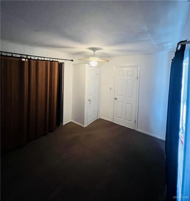593 5th St, Raymondville, TX 78580 - empty room with dark colored carpet, ceiling fan, and baseboards