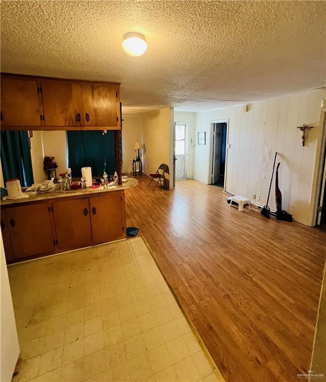 593 5th St, Raymondville, TX 78580 - kitchen featuring a textured ceiling, light floors, brown cabinetry, and open floor plan