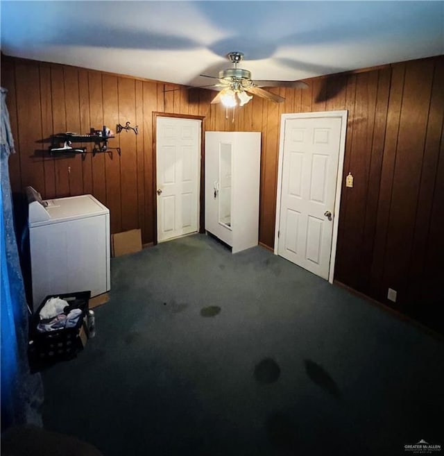 593 5th St, Raymondville, TX 78580 - foyer with washer / dryer, a ceiling fan, wood walls, and dark colored carpet