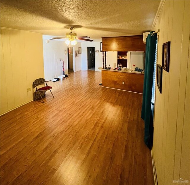 593 5th St, Raymondville, TX 78580 - unfurnished living room with wood finished floors, a textured ceiling, and ceiling fan