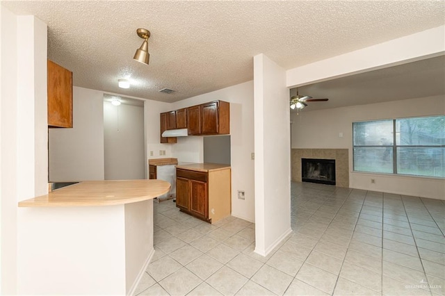 5111 Other, San Antonio, TX 78217 - kitchen with light tile patterned floors, ceiling fan, a textured ceiling, a peninsula, and light countertops