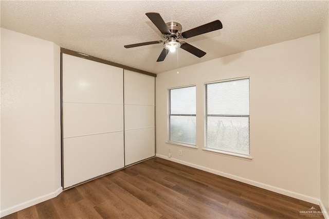 5111 Other, San Antonio, TX 78217 - unfurnished bedroom featuring dark wood-type flooring, baseboards, a closet, and a textured ceiling