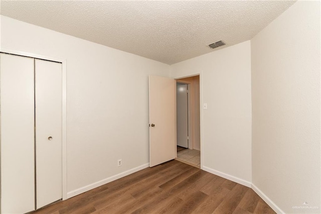 5111 Other, San Antonio, TX 78217 - unfurnished bedroom featuring wood finished floors, a closet, a textured ceiling, and baseboards
