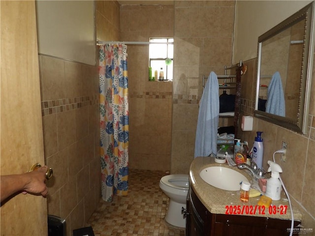 bathroom with a shower with curtain, vanity, toilet, and tile walls