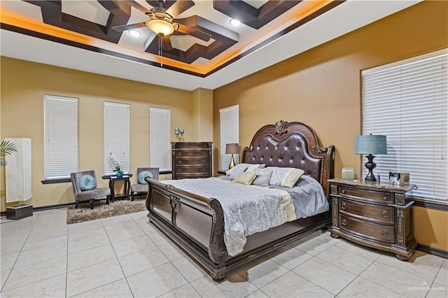 tiled bedroom with a raised ceiling and ceiling fan