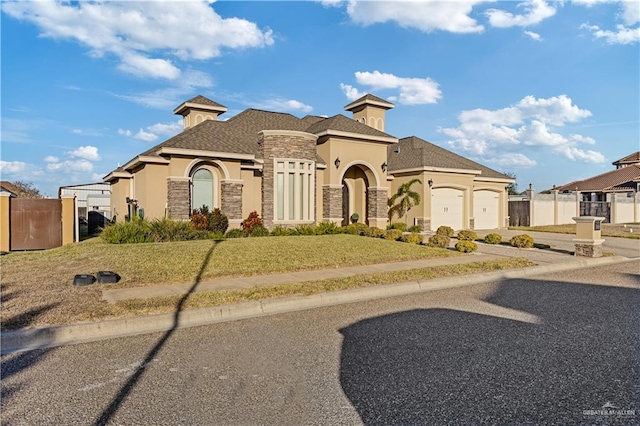 mediterranean / spanish house with a garage and a front lawn