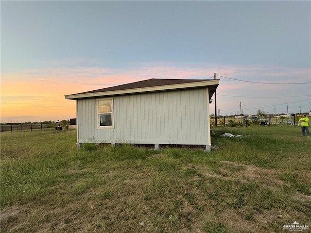 property exterior at dusk featuring a yard