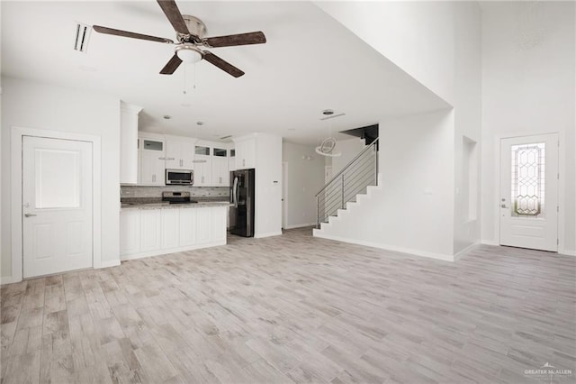 unfurnished living room featuring light hardwood / wood-style floors and ceiling fan