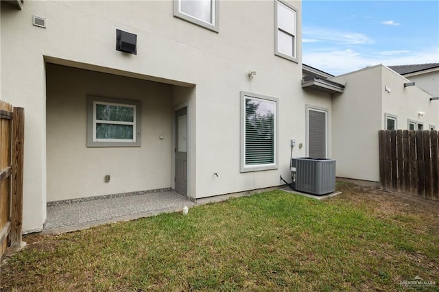 back of house featuring a yard and central air condition unit