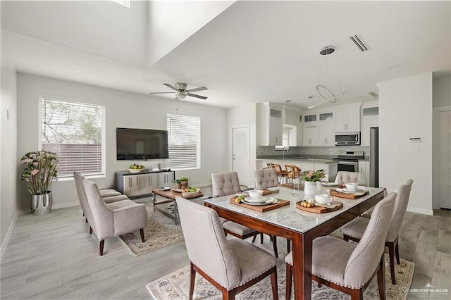 dining room with ceiling fan and light hardwood / wood-style flooring