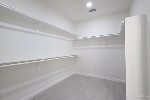 spacious closet featuring light hardwood / wood-style floors