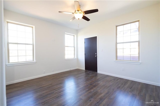 empty room with ceiling fan, dark hardwood / wood-style flooring, and a healthy amount of sunlight