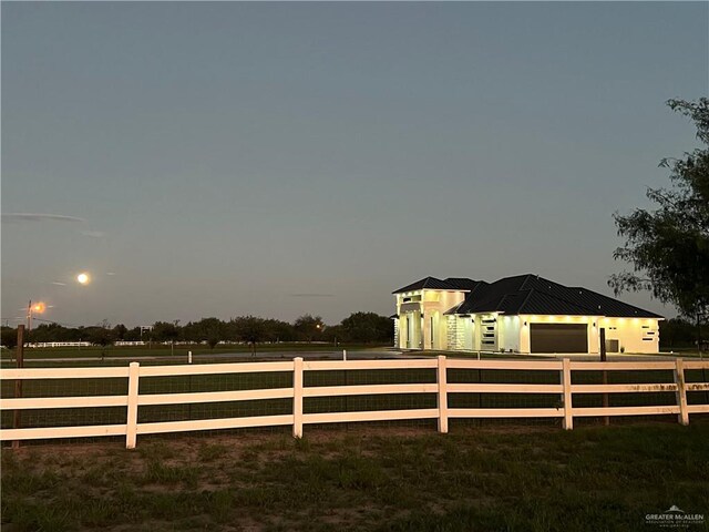 yard at dusk featuring a garage