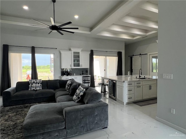 living room with a barn door, wine cooler, a healthy amount of sunlight, and sink