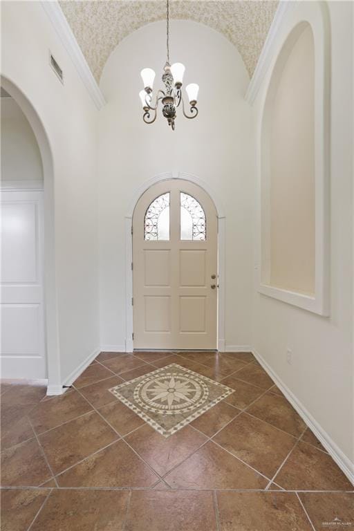 406 Casiano St, Donna, TX 78537 - tiled foyer entrance featuring a chandelier, high vaulted ceiling, arched walkways, and baseboards