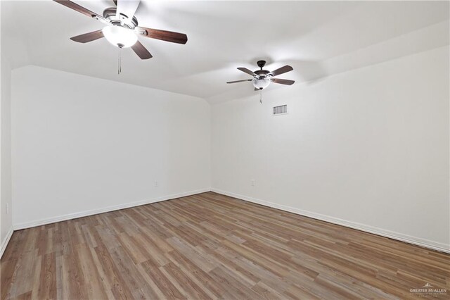 406 Casiano St, Donna, TX 78537 - empty room featuring wood finished floors, ceiling fan, lofted ceiling, and baseboards
