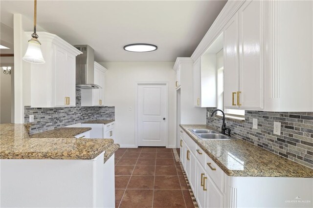 406 Casiano St, Donna, TX 78537 - kitchen featuring wall chimney exhaust hood, a sink, backsplash, white cabinets, and baseboards