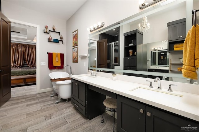 1801 Ozark Ave, Mcallen, TX 78504 - ensuite bathroom with wood finished floors, a freestanding tub, a chandelier, double vanity, and baseboards