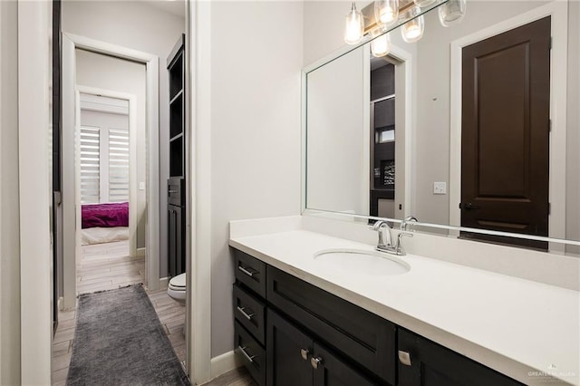 1801 Ozark Ave, Mcallen, TX 78504 - bathroom with vanity, toilet, baseboards, and wood finished floors