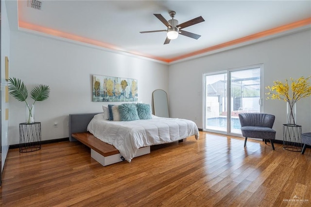 bedroom featuring hardwood / wood-style flooring, ceiling fan, and access to outside