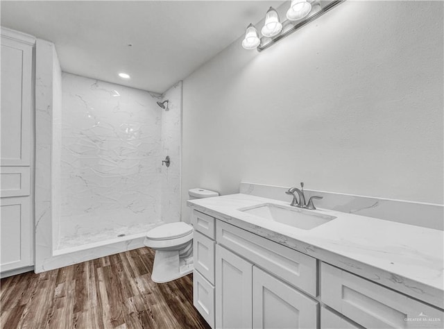 bathroom with vanity, a shower stall, toilet, and wood finished floors