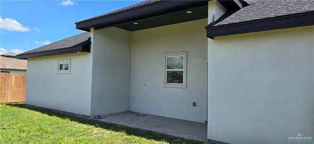3808 Revilla St, Edinburg, TX 78542 - view of side of property with stucco siding, a shingled roof, fence, and a lawn