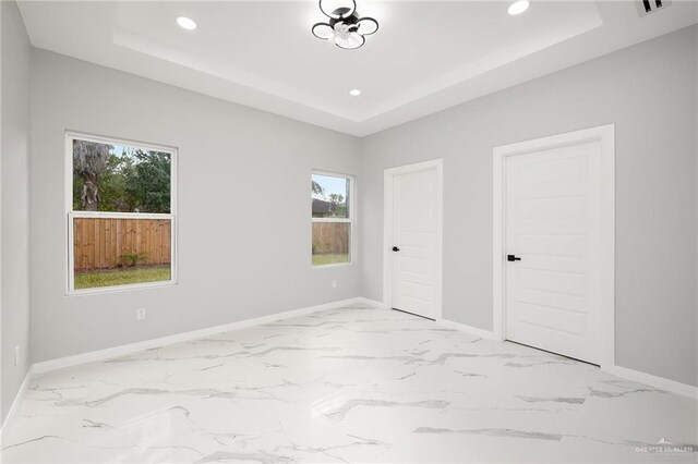 unfurnished bedroom with a raised ceiling