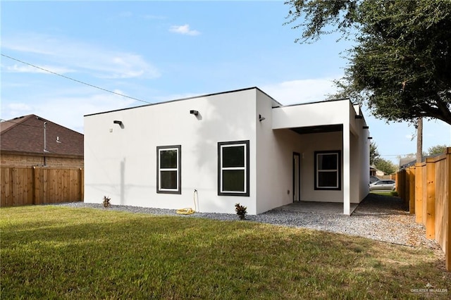 rear view of property featuring a patio and a lawn