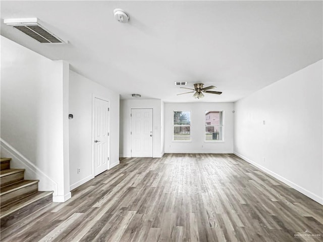 unfurnished living room with ceiling fan and wood-type flooring