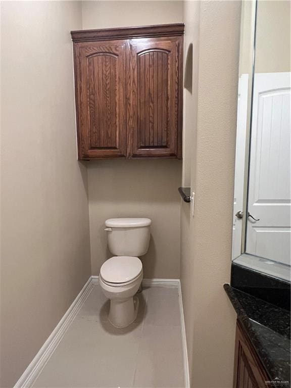 bathroom with tile patterned flooring, vanity, toilet, and baseboards