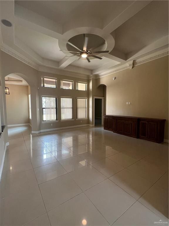 unfurnished room featuring arched walkways, light tile patterned floors, coffered ceiling, a ceiling fan, and baseboards