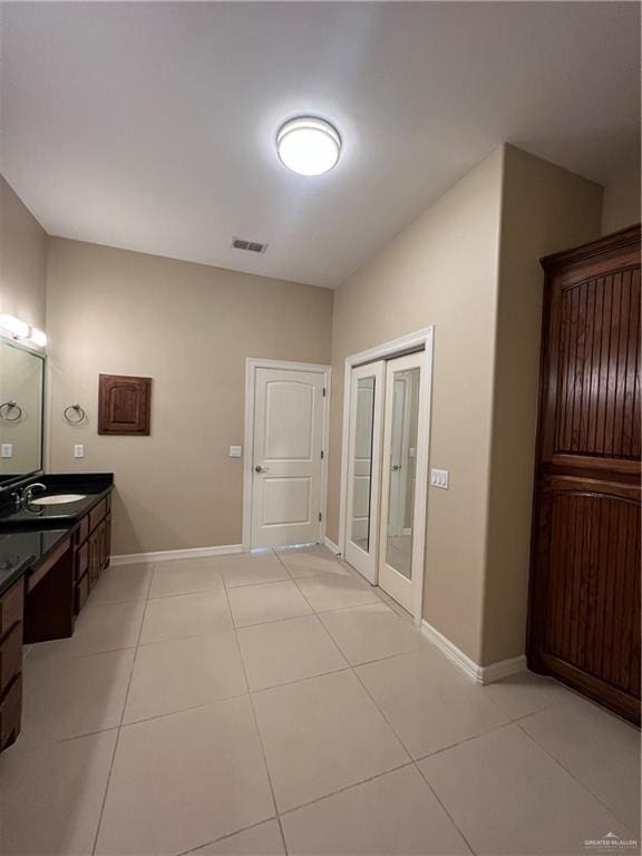 bathroom featuring tile patterned flooring, visible vents, baseboards, and vanity