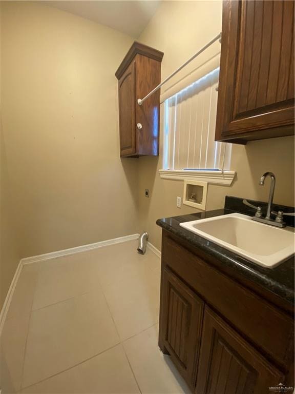 laundry room with light tile patterned floors, hookup for a washing machine, hookup for an electric dryer, a sink, and baseboards