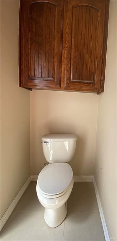 bathroom with tile patterned flooring, toilet, and baseboards