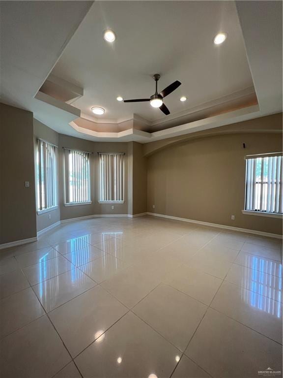 unfurnished room featuring light tile patterned flooring, a raised ceiling, and a wealth of natural light